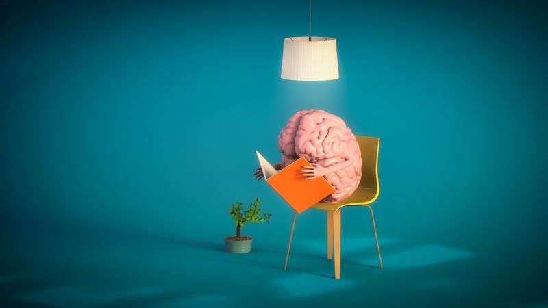 3D rendering of a brain sat in a yellow chair holding a book with weird hands and reading it, a plant in the background and a light above it, on a dark blue background