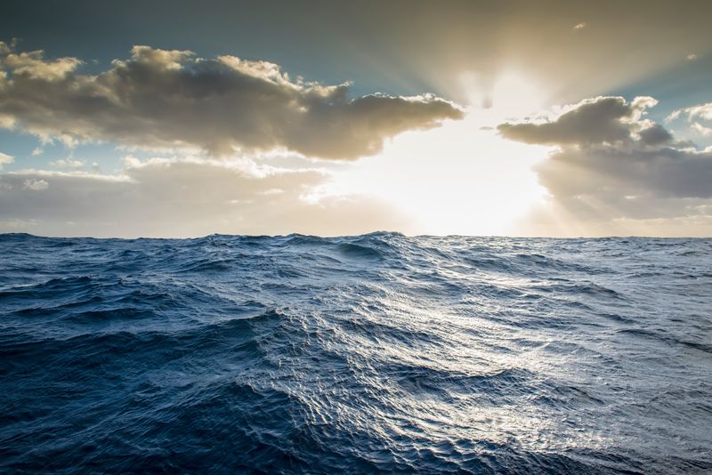 a view of the ocean with the sunny, cloudy sky above