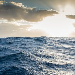 a view of the ocean with the sunny, cloudy sky above