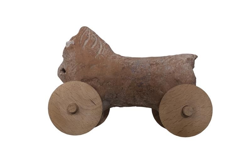 Ancient Clay Horse toy with wheels on white background