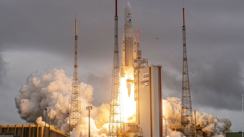 The Arinae 5 Rocket with two booster is seen with flame coming out from its engines almost suprassing the launch tower