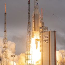 The Arinae 5 Rocket with two booster is seen with flame coming out from its engines almost suprassing the launch tower