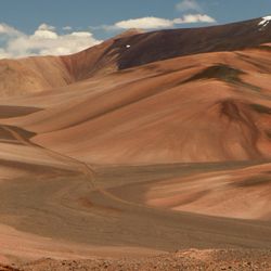 A dirt road high in the Andes mountains. Traveling along the route across the arid desert dunes and mountain range.