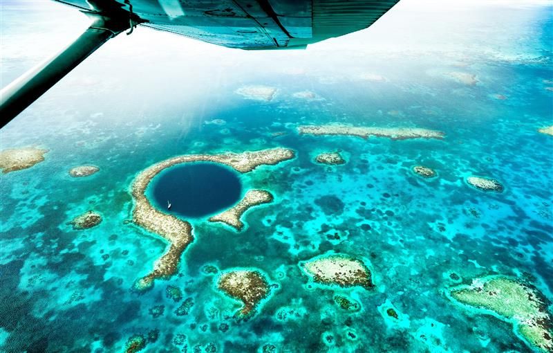 Aerial view of The Great Blue Hole taken by a plane flying over the Belize Barrier Reef Reserve System