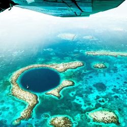 Aerial view of The Great Blue Hole taken by a plane flying over the Belize Barrier Reef Reserve System