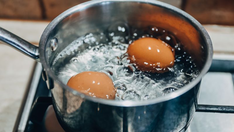 Saucepan with boiling eggs on a gas stove