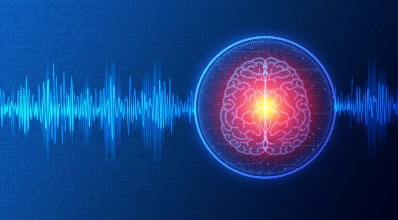 blue frequency waves against dark blue background; blue circle on the right around a diagram of the brain viewed from above with glowing red and yellow towards the middle