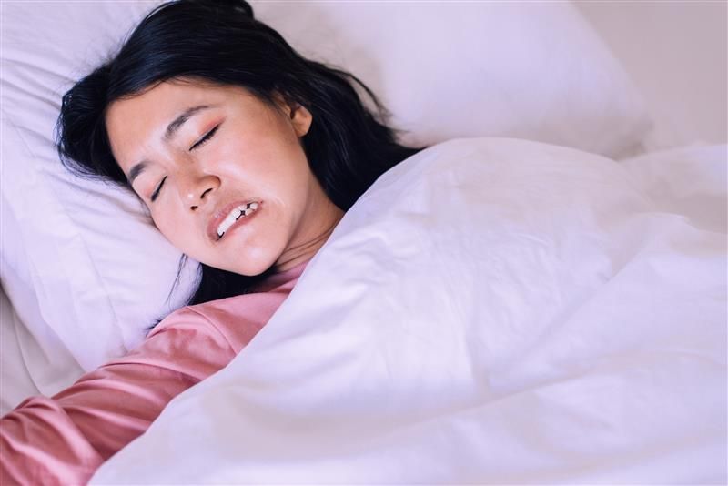 Woman with bruxism grinding teeth in her sleep