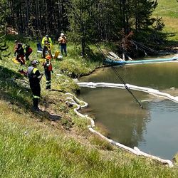  A crew of emergency personal retrieve a car underwater in a thermal feature.