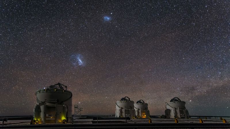 Hanging over the site are the prominent Small and Large Magellanic Clouds, visible only in the southern sky. These two irregular dwarf galaxies are in the Local Group and so are companion galaxies to our own galaxy, the Milky Way