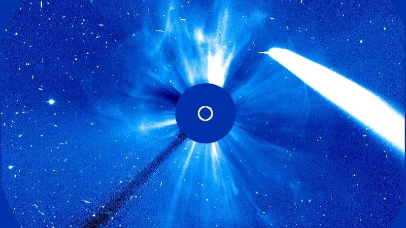 The comet is a bright strip of light on the side. At the center the view of the Sun is blocked by the coronagraph. Whsipy filaments and bright stripes are visible around the coronagraph 360 degrees as the CEM is going in the whole field of view