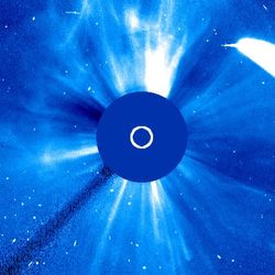 The comet is a bright strip of light on the side. At the center the view of the Sun is blocked by the coronagraph. Whsipy filaments and bright stripes are visible around the coronagraph 360 degrees as the CEM is going in the whole field of view