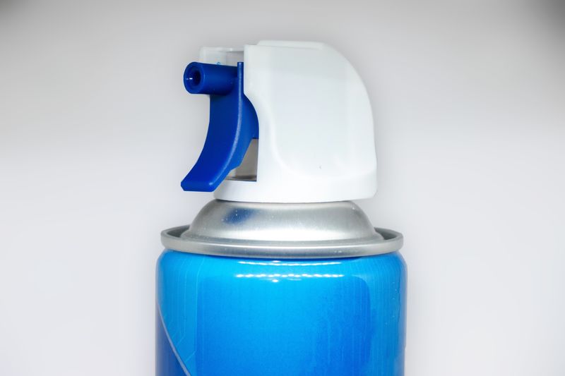 close up of nozzle of a blue can of compressed air