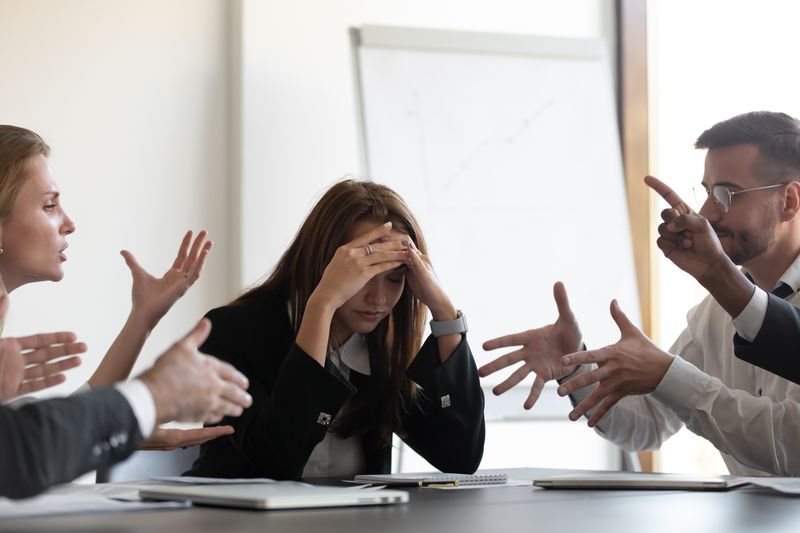 Five people having an argument, one with her head in her hands