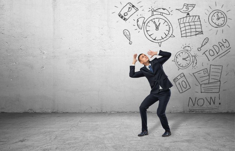 man in business suit being attacked by line drawings of clocks, calendars, paperwork etc