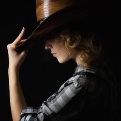 Woman in a cowboy's hat isolated on black background