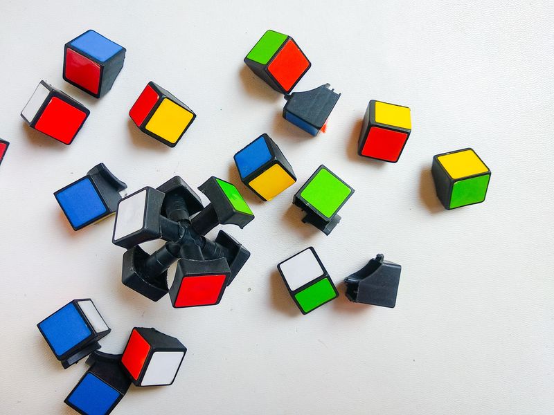 Broken rubik's cube pieces on white background