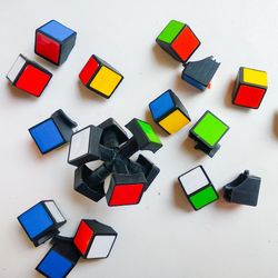 Broken rubik's cube pieces on white background