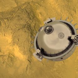 A spherical metal probe is seen floating above some yellow rugged mountains