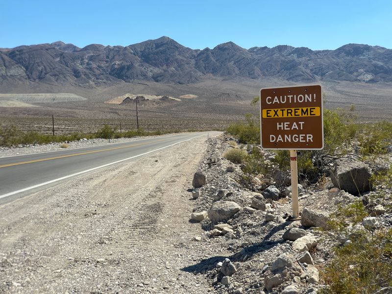 Road in Death Valley with an extreme heat warning sign