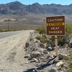 Road in Death Valley with an extreme heat warning sign