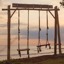 Empty swings in front of a sunset