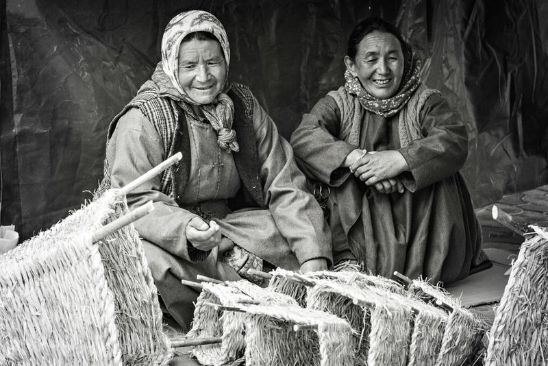 Old Tibetan women selling wicker baskets on the market in Leh, India.