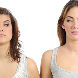 Two women standing side by side giving each other a side eye