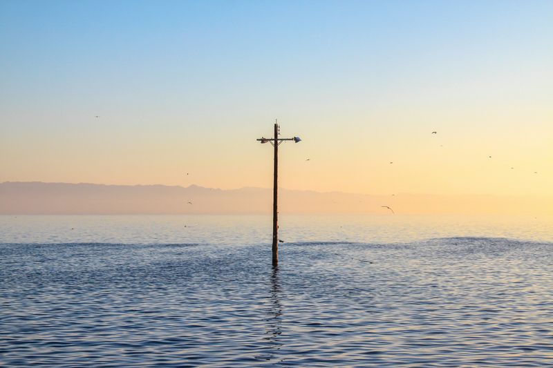 A submerged lamppost in a flooded scene.