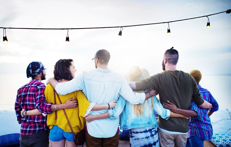 group of adults standing in a line facing away from the camera with their arms around each other