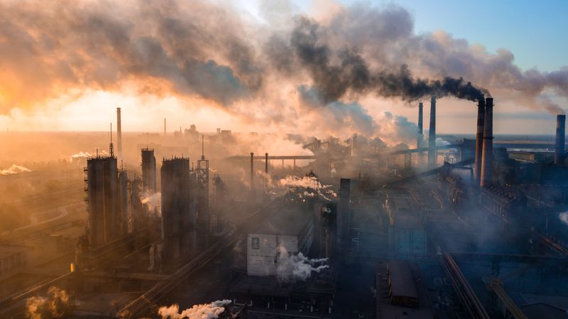 A picture of an industrial complex releasing smoke from many chimneys