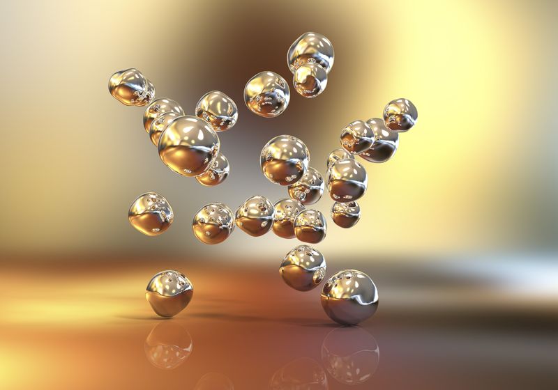 illustrations of spherical gold nanoparticles floating on a background of different shades of gold