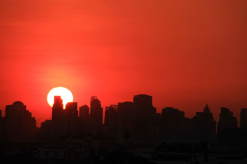 The skyline of a city as the Sun sets make the sky in the summer