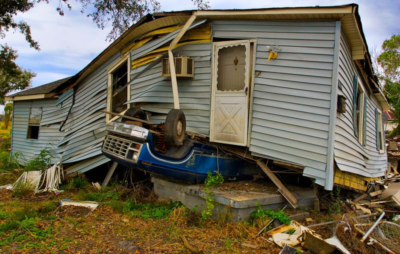 Hurricane damage in New Orleans, an upside-down truck underneath a damaged house