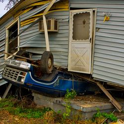 Hurricane damage in New Orleans, an upside-down truck underneath a damaged house