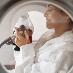 Side view of happy woman receiving oxygen therapy at hyperbaric chamber at health spa.