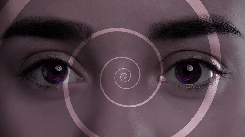 eyes with purple circles in the irises superimposed with a spiral to signify entering a hypnotic state