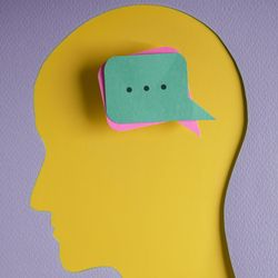 Paper cutout of the human head with message boxes as thoughts