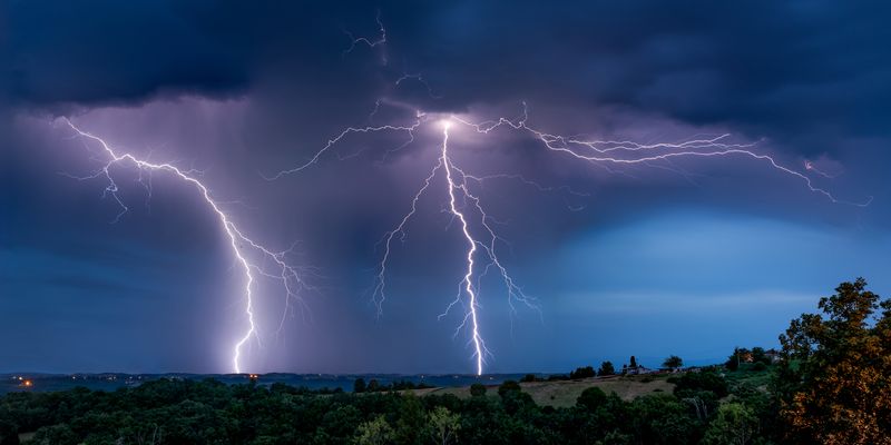 Lightning strikes the ground in a summer storm all over the sky in southern France.