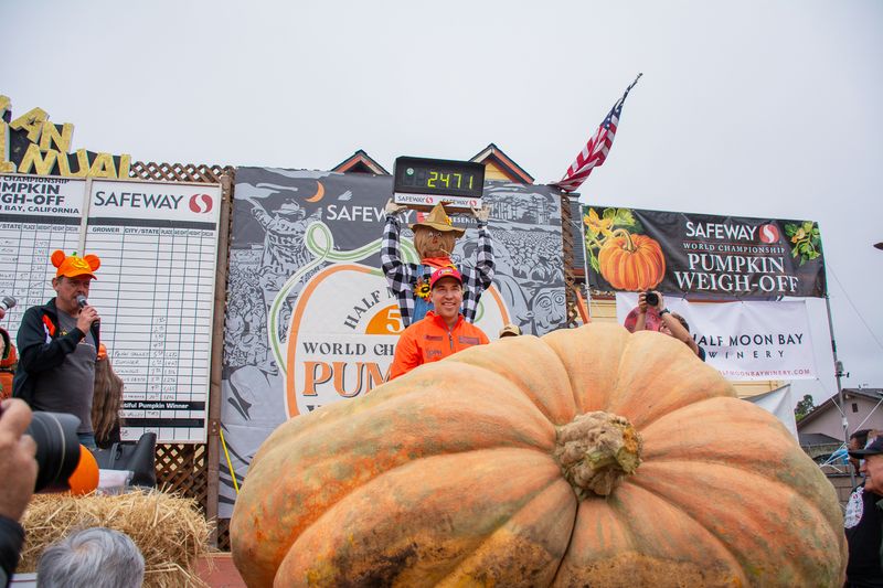 Man standing beside his massive award-winning pumpkin