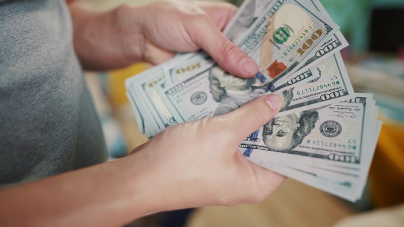 close up of hands counting 100 dollar bills