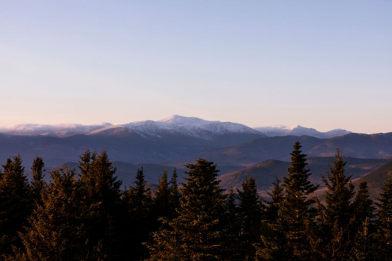 Sunset, distant mountains in the background, forest in the foreground