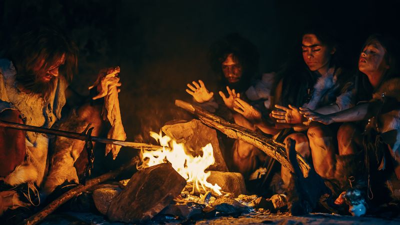 Neanderthal family cooking over bonfire