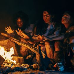 Neanderthal family cooking over bonfire