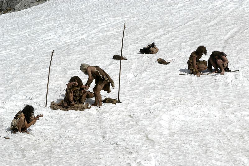 Prehistoric caveman Neanderthals on a snow Ice Age background