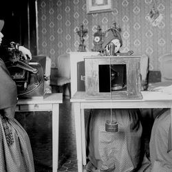 Three nuns sitting a table with photographic plates in front of them. The picture is in black and white