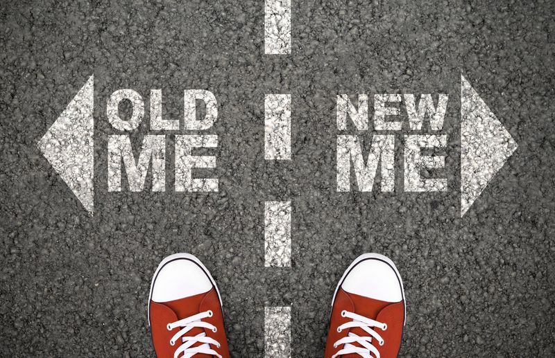 road with arrows either side of the centre line; one pointing to the left is labelled "old me", while one pointing to the right is labelled "new me", and there are red sneakers side by side of the line