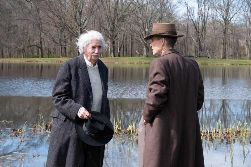 Tom Conti as Albert Einstein and Cillian Murphy as J. Robert Oppenheimer in OPPENHEIMER, written, produced, and directed by Christopher Nolan. 