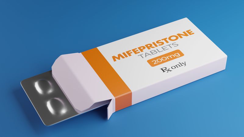 Packet of mifepristone on a blue background