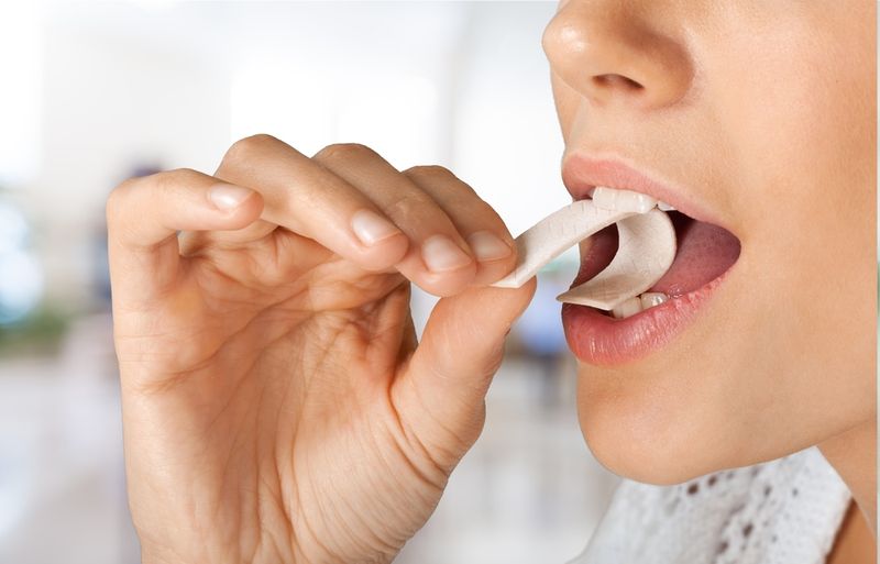 Person putting a strip of gum into their mouth